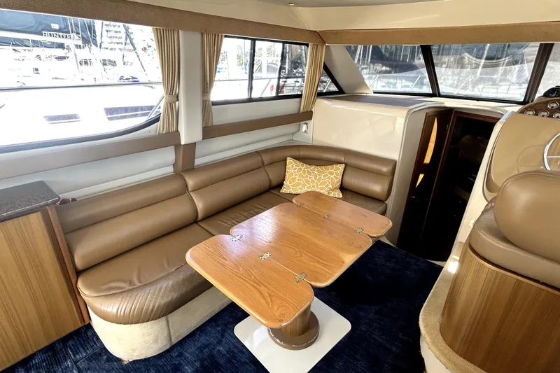 Slide: The Image of Interior of 2002 Bayliner 3488 Avanti yacht with leather seating and wooden table. - 22