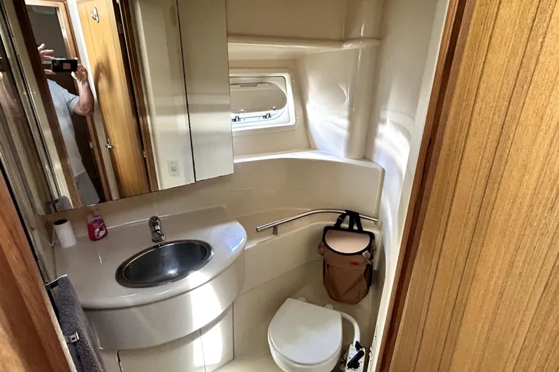 Slide: The Image of Bathroom interior of 2002 Bayliner 3488 Avanti yacht, featuring sink, toilet, and window. - 26