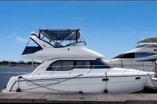 Slide: The Image of 2002 Bayliner 3488 Avanti yacht docked, featuring sleek design and spacious upper deck. - 3