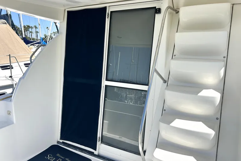 Slide: The Image of 2002 Bayliner 3488 Avanti yacht with stairs and sliding door, docked at marina. - 36