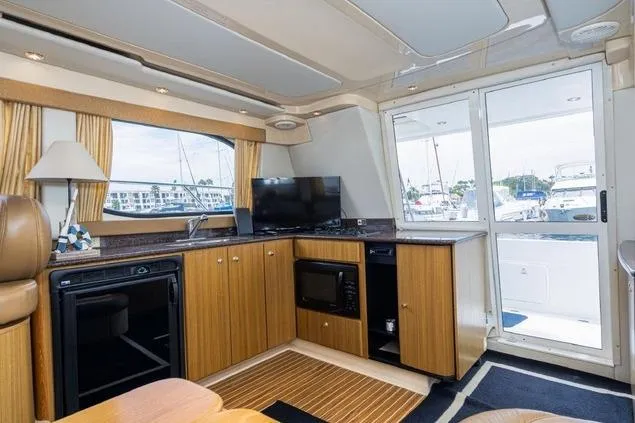 Slide: The Image of Interior of 2002 Bayliner 3488 Avanti yacht with kitchenette and marina view. - 5