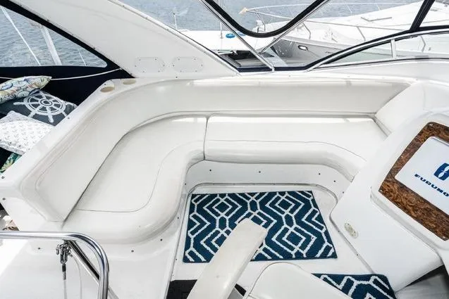 Slide: The Image of 2002 Bayliner 3488 Avanti boat interior with white seating and geometric-patterned rug. - 7