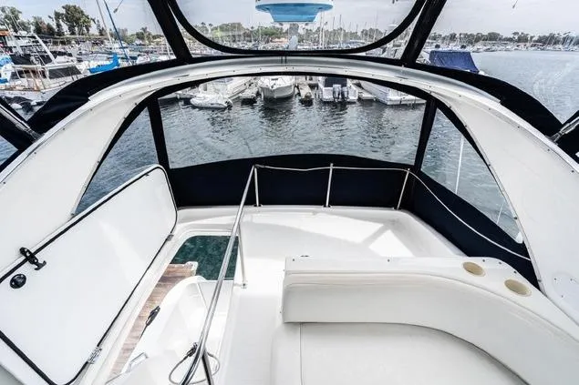 Slide: The Image of 2002 Bayliner 3488 Avanti yacht interior with marina view, featuring sleek white seating. - 8