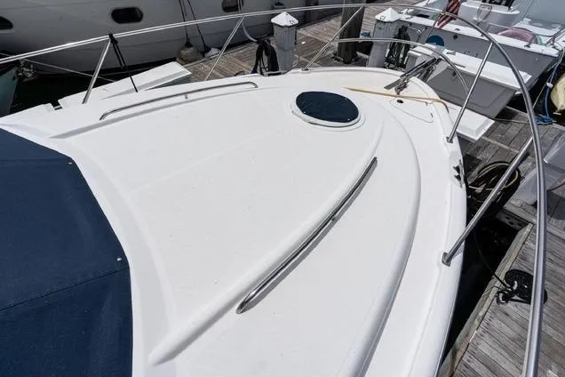 Slide: The Image of 2002 Bayliner 3488 Avanti yacht deck with railing and hatch, docked at marina. - 9