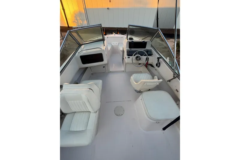 Slide: The Image of 1997 Grady-White Tournament 192 boat interior with white seating and steering console. - 14