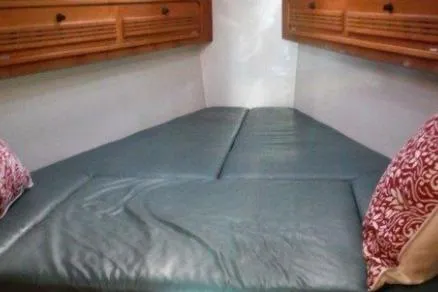 Slide: The Image of Cozy cabin interior of a 2000 C&C 110 sailboat with cushioned bed and wooden storage. - 15