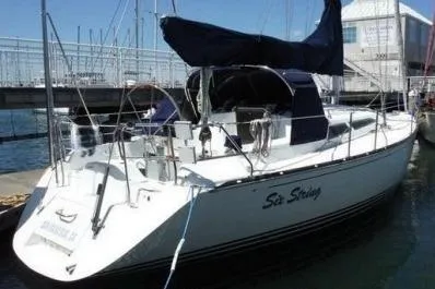 Slide: The Image of Sailboat docked at marina, C&C 110 model, year 2000, with blue canopy. - 2