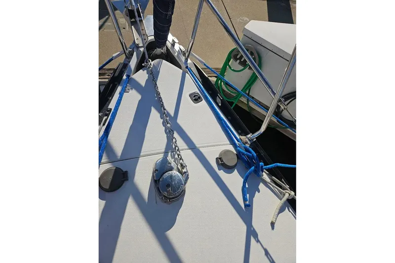 Slide: The Image of Bow of a C&C 110 sailboat, featuring anchor chain and blue ropes, 2000 model. - 21