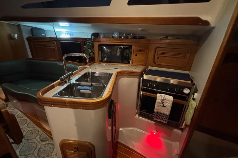 Slide: The Image of Cozy yacht kitchen interior with sink, stove, and wooden cabinetry in a C&C 110, 2000 model. - 6