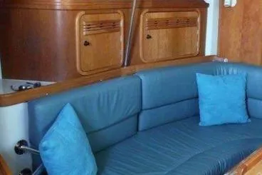 Slide: The Image of Interior of a 2000 C&C 110 yacht with blue seating and wooden cabinetry. - 7