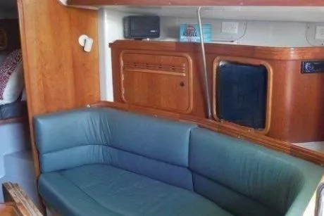 Slide: The Image of Interior of 2000 C&C 110 sailboat with blue seating and wooden cabinetry. - 8
