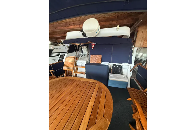 Slide: The Image of 1983 Ocean Alexander 43 Flush Aft Deck with wooden furniture and nautical decor. - 16