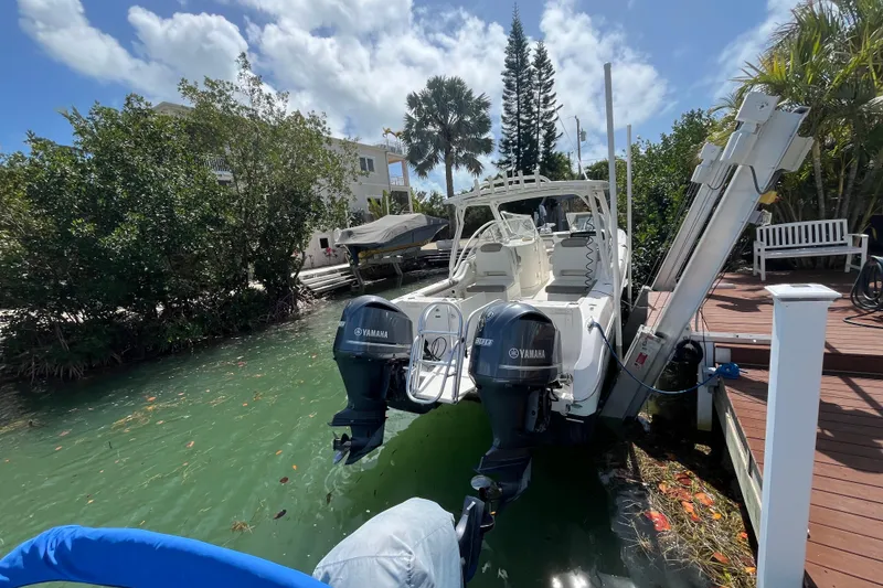 The Image of 2020 World Cat 296 DC boat docked with Yamaha engines, surrounded by lush greenery. - 1