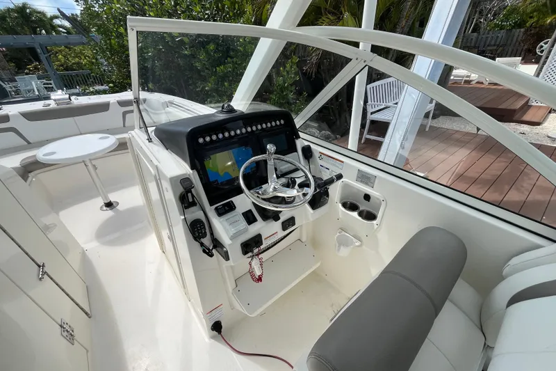 Slide: The Image of 2020 World Cat 296 DC boat cockpit with steering wheel and navigation display. - 13