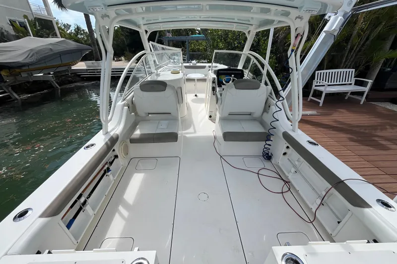 Slide: The Image of 2020 World Cat 296 DC boat interior with seating and helm, docked by the water. - 17