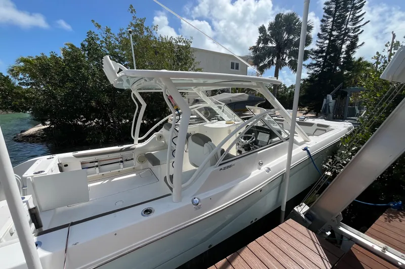 Slide: The Image of 2020 World Cat 296 DC boat docked near lush greenery and clear skies. - 3