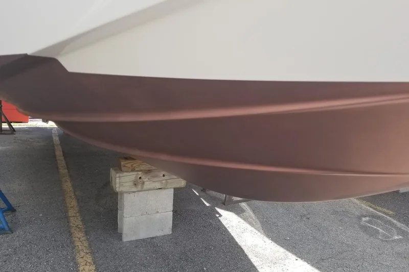 Slide: The Image of 2012 Chaparral 330 Signature boat hull on blocks in a parking area. - 11