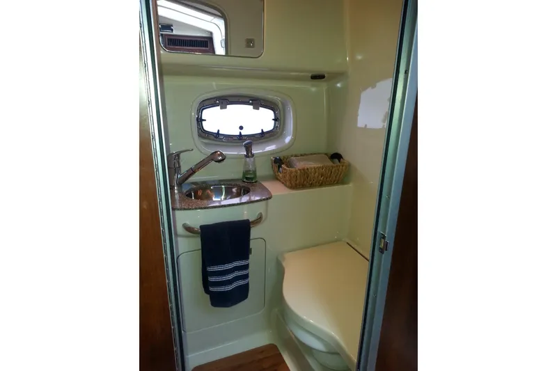 Slide: The Image of 2012 Chaparral 330 Signature boat bathroom with sink, window, and storage basket. - 8