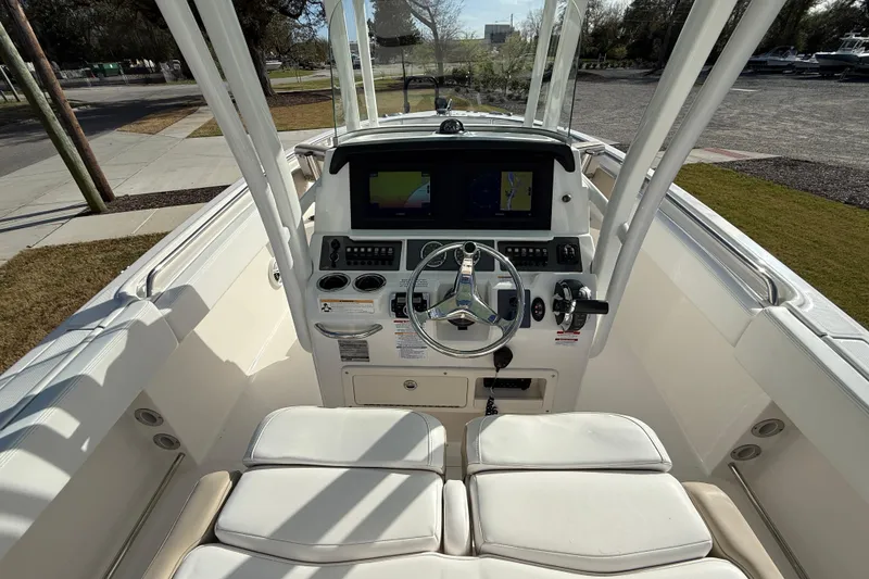 Slide: The Image of 2018 Robalo R242 Center Console boat interior with steering wheel and navigation display. - 13