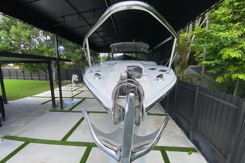 Slide: The Image of 2005 Formula 330 Sun Sport boat docked under a covered area, surrounded by greenery. - 10
