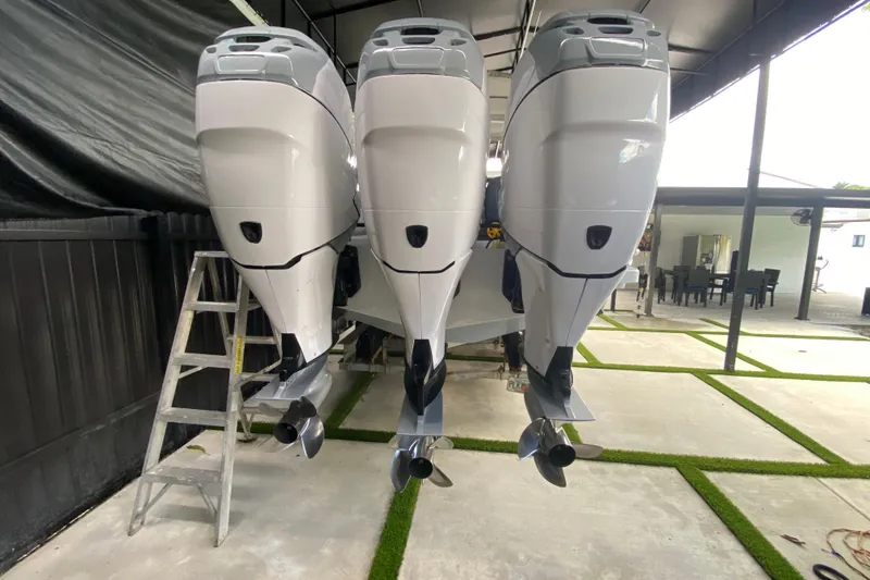 Slide: The Image of Triple outboard motors on a 2005 Formula 330 Sun Sport boat in a covered area. - 42