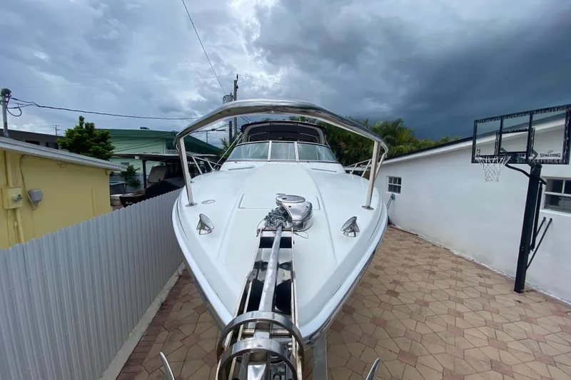Slide: The Image of 2009 Formula 330 Sun Sport boat parked in a driveway under cloudy skies. - 2