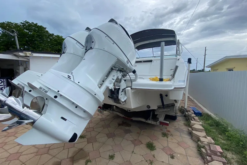 Slide: The Image of 2009 Formula 330 Sun Sport boat with dual outboard motors on a paved driveway. - 25