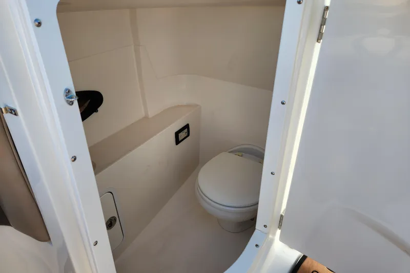 Slide: The Image of 2016 Hurricane SunDeck 2400 OB boat interior bathroom with toilet. - 11