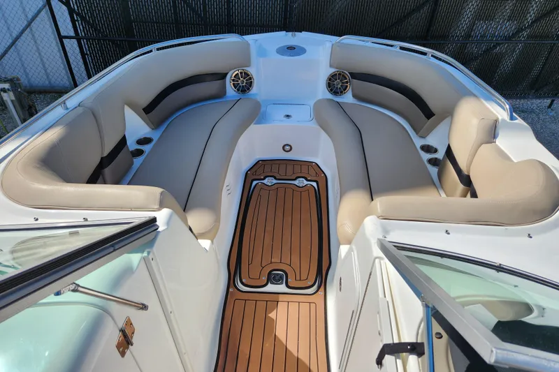 Slide: The Image of 2016 Hurricane SunDeck 2400 OB boat interior with beige seating and wood-style flooring. - 13