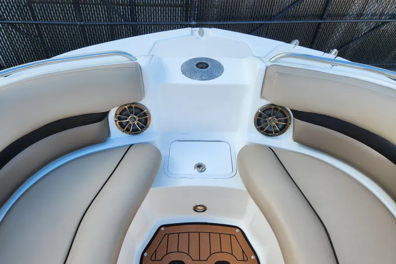 Slide: The Image of 2016 Hurricane SunDeck 2400 OB boat interior with beige seating and speakers. - 16