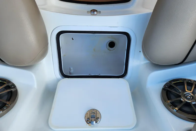 Slide: The Image of 2016 Hurricane SunDeck 2400 OB boat storage compartment with speakers and seating. - 17