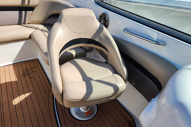 Slide: The Image of Captain's chair on 2016 Hurricane SunDeck 2400 OB boat, featuring beige upholstery and wood flooring. - 23