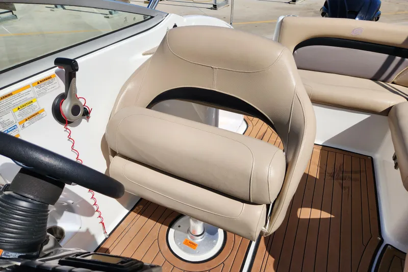 Slide: The Image of Captain's seat on 2016 Hurricane SunDeck 2400 OB boat with teak flooring. - 24