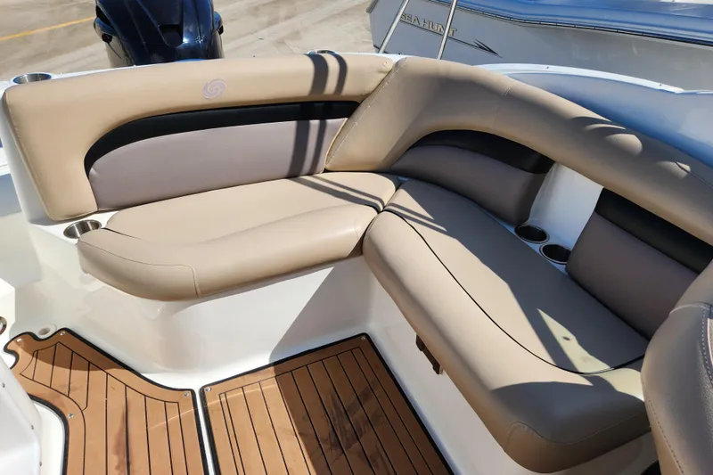 Slide: The Image of 2016 Hurricane SunDeck 2400 OB boat interior with beige seating and wooden flooring. - 26