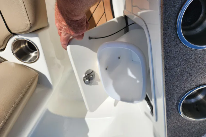 Slide: The Image of 2016 Hurricane SunDeck 2400 OB boat interior with storage compartment and cup holders. - 29