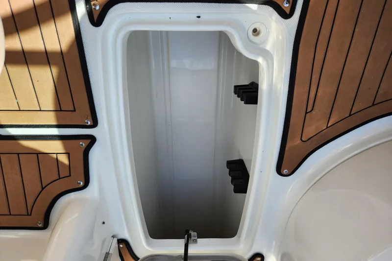 Slide: The Image of Storage compartment on 2016 Hurricane SunDeck 2400 OB boat with wood-patterned flooring. - 30