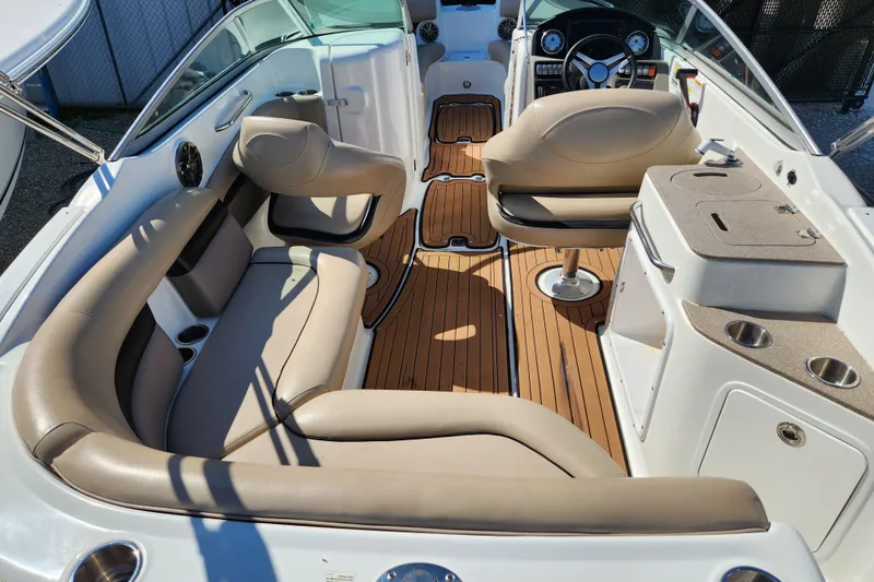 Slide: The Image of 2016 Hurricane SunDeck 2400 OB interior with beige seating and wood-style flooring. - 6