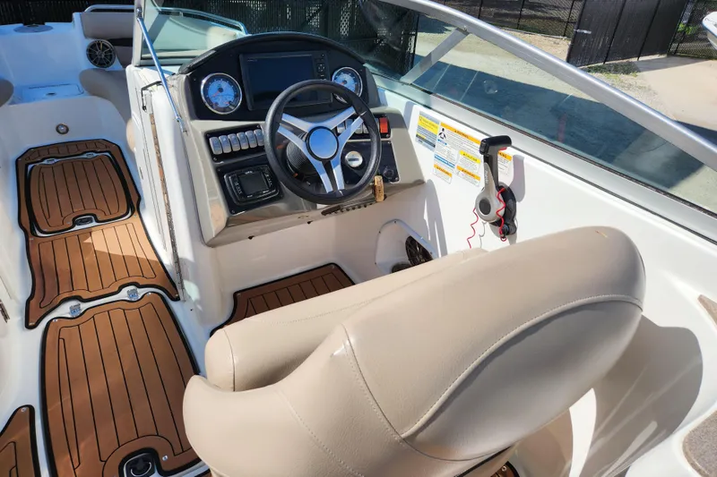 Slide: The Image of 2016 Hurricane SunDeck 2400 OB boat interior with steering wheel and control panel. - 8