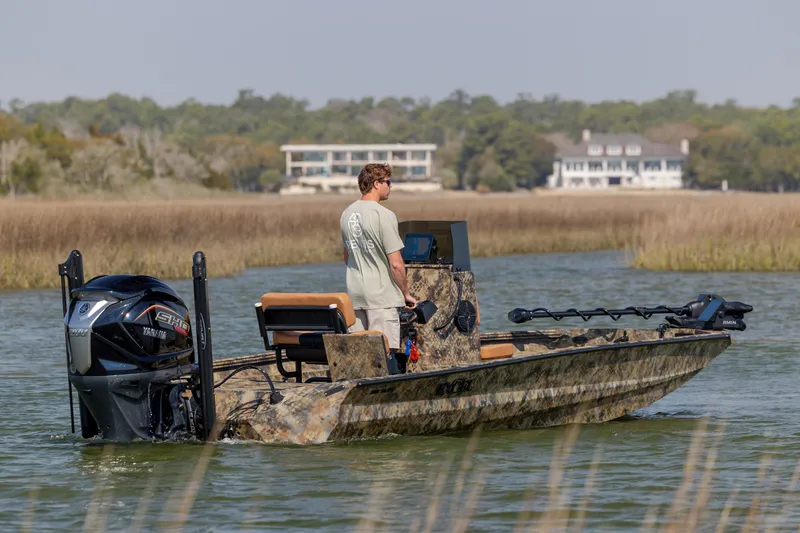 The Image of 2026 Excel 203 Bay Pro Elite boat on water, with person navigating, scenic background. - 0