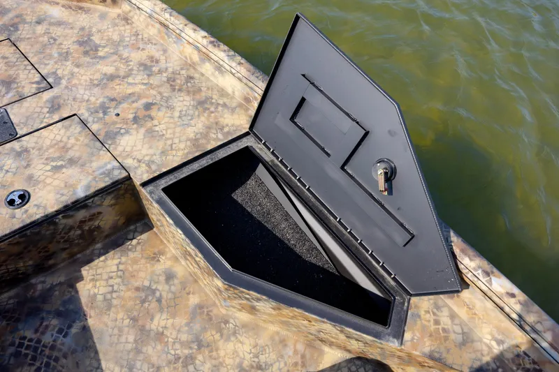 Slide: The Image of Open storage compartment on 2026 Excel 203 Bay Pro Elite boat, near water. - 16