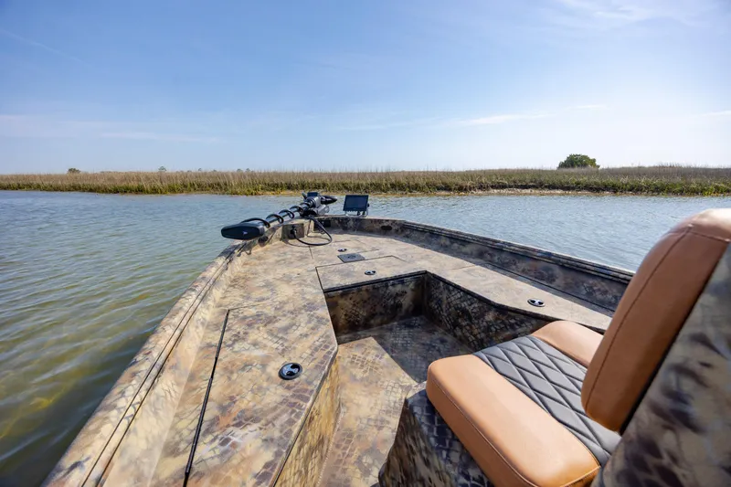 Slide: The Image of 2026 Excel 203 Bay Pro Elite boat on calm water, featuring camo design and comfortable seating. - 18