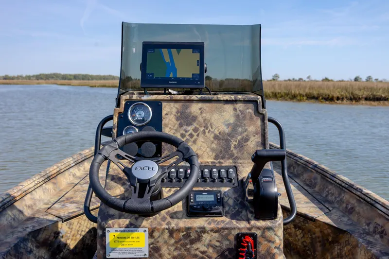 Slide: The Image of 2026 Excel 203 Bay Pro Elite boat dashboard with GPS, steering wheel, and controls on water. - 24