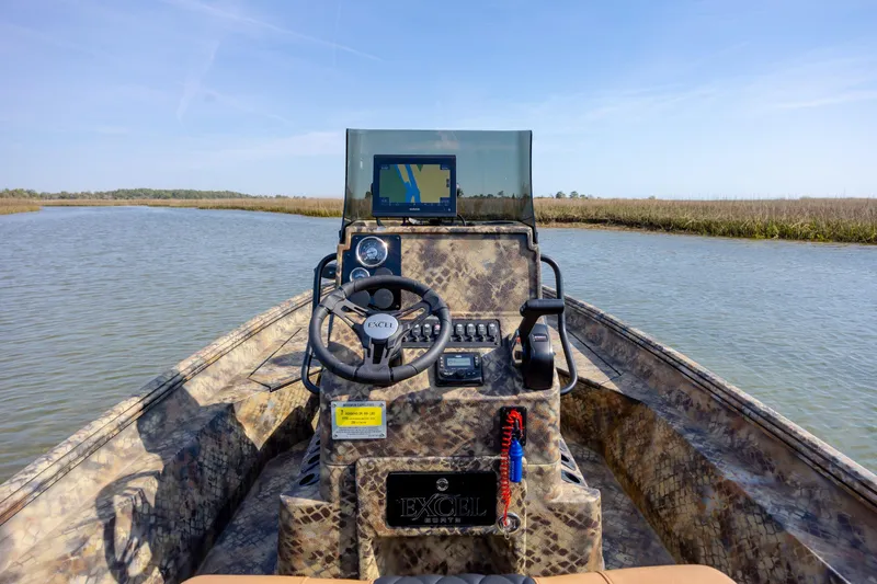 Slide: The Image of 2026 Excel 203 Bay Pro Elite boat navigating a serene waterway. - 25