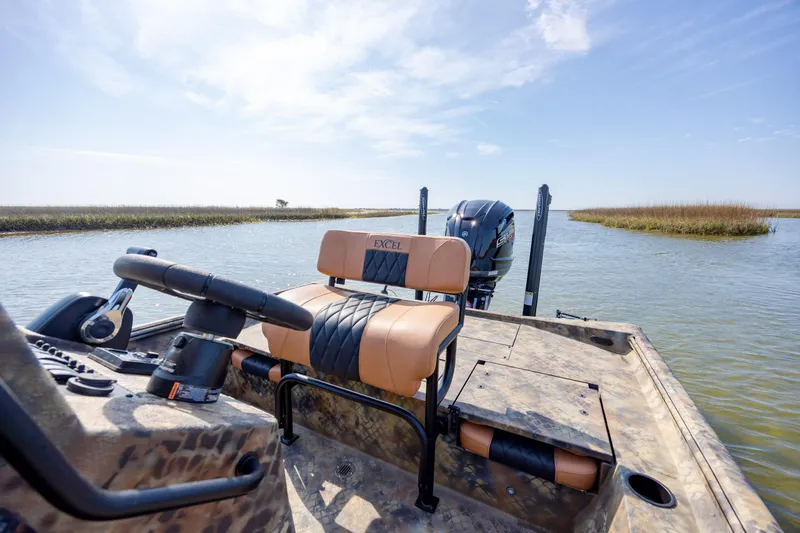 Slide: The Image of 2026 Excel 203 Bay Pro Elite boat on calm water, featuring comfortable seating and modern design. - 27