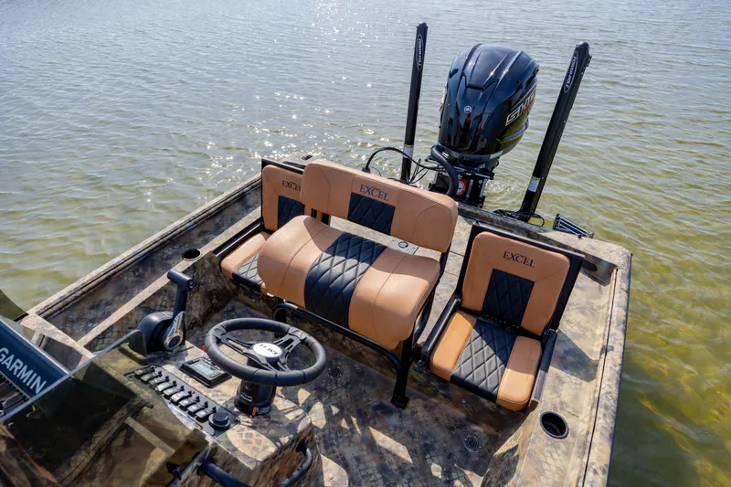 Slide: The Image of 2026 Excel 203 Bay Pro Elite boat interior with tan and black seating on water. - 28