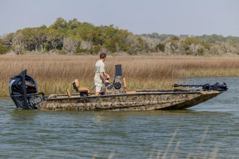 Slide: The Image of Man standing on 2026 Excel 203 Bay Pro Elite boat in marshland. - 3