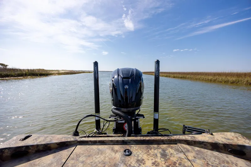 Slide: The Image of 2026 Excel 203 Bay Pro Elite boat on a serene waterway under a clear blue sky. - 34
