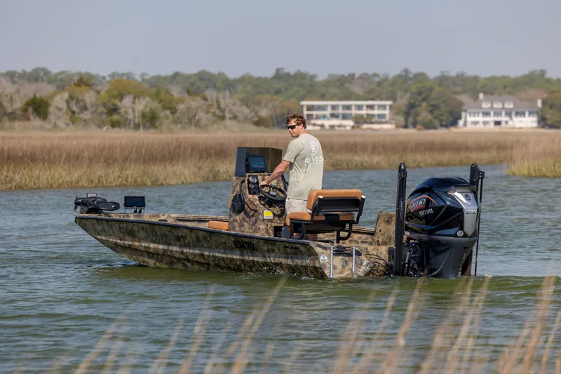 Slide: The Image of Man operating 2026 Excel 203 Bay Pro Elite boat on a calm river. - 8
