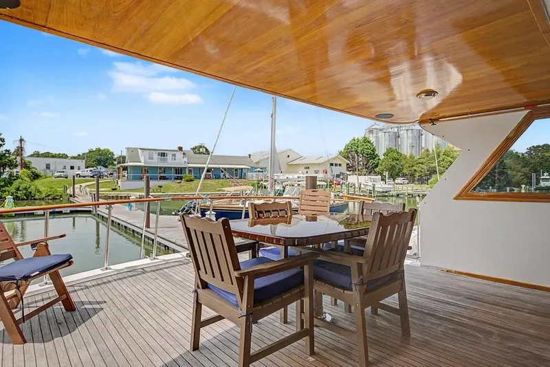 Slide: The Image of Outdoor dining area on 1989 Jefferson Marquessa 63 yacht, overlooking marina and waterfront buildings. - 17