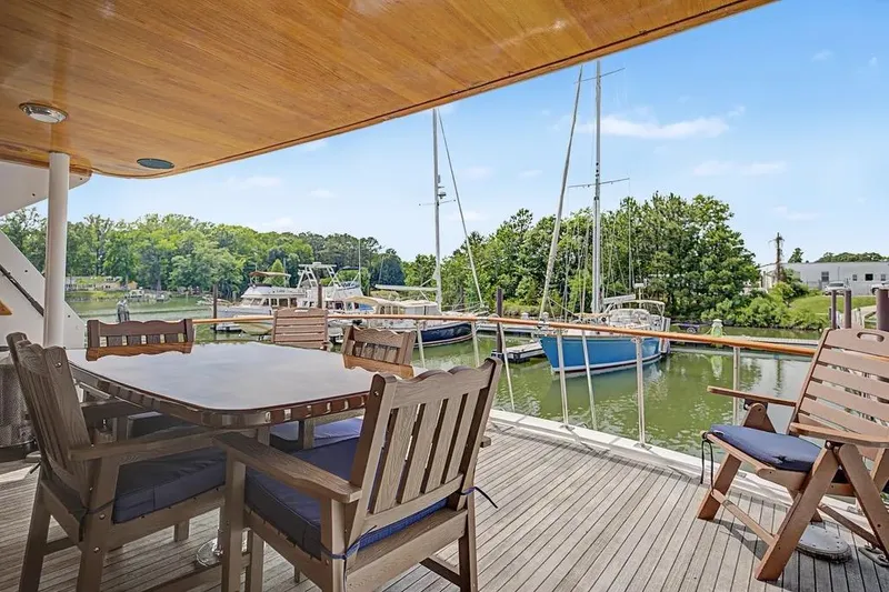 Slide: The Image of Outdoor deck of 1989 Jefferson Marquessa 63 yacht with wooden furniture and marina view. - 18